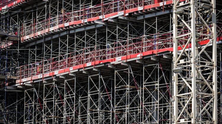 Built to suit commercial project management with project manager reviewing construction plans