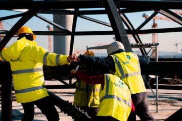 Built to suit commercial project management with project manager reviewing construction blueprints