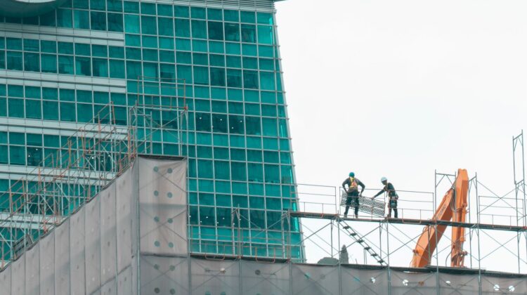 Commercial construction project manager inspecting blueprint at construction site