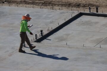 Construction audit importance in project success with project manager reviewing site blueprint