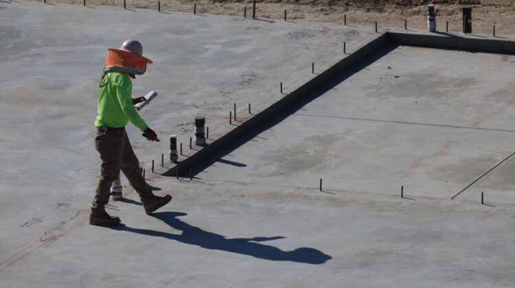 Construction audit importance in project success with project manager reviewing site blueprint