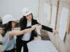 design build project management process with construction manager reviewing blueprints on site
