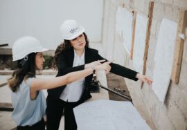 design build project management process with construction manager reviewing blueprints on site