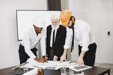 office refurbishment project monitoring with project manager reviewing blueprint onsite