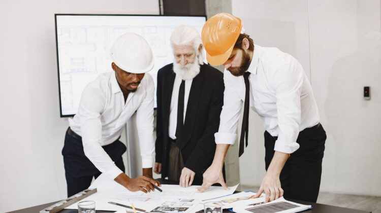 office refurbishment project monitoring with project manager reviewing blueprint onsite