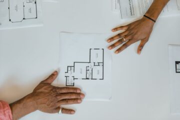Vendor management in construction project tracking with project manager reviewing blueprints
