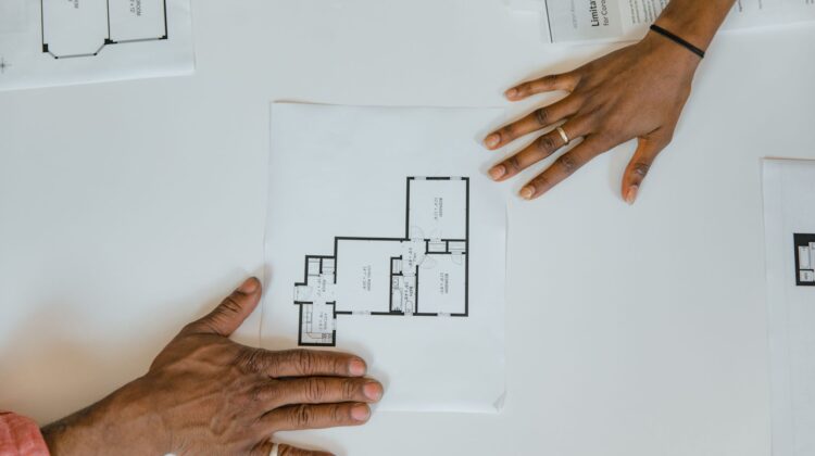 Vendor management in construction project tracking with project manager reviewing blueprints
