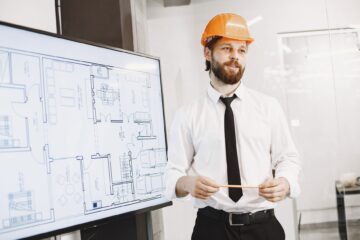 Construction project manager reviewing procurement strategy documents on site