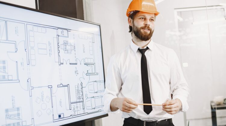 Construction project manager reviewing procurement strategy documents on site