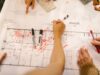 Construction project manager reviewing procurement planning documents on site