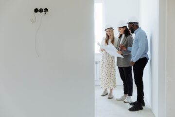 Construction project manager using time management techniques reviewing blueprint on site