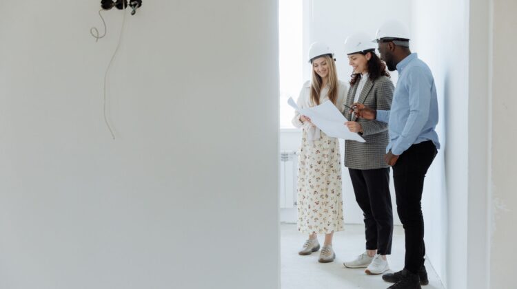 Construction project manager using time management techniques reviewing blueprint on site